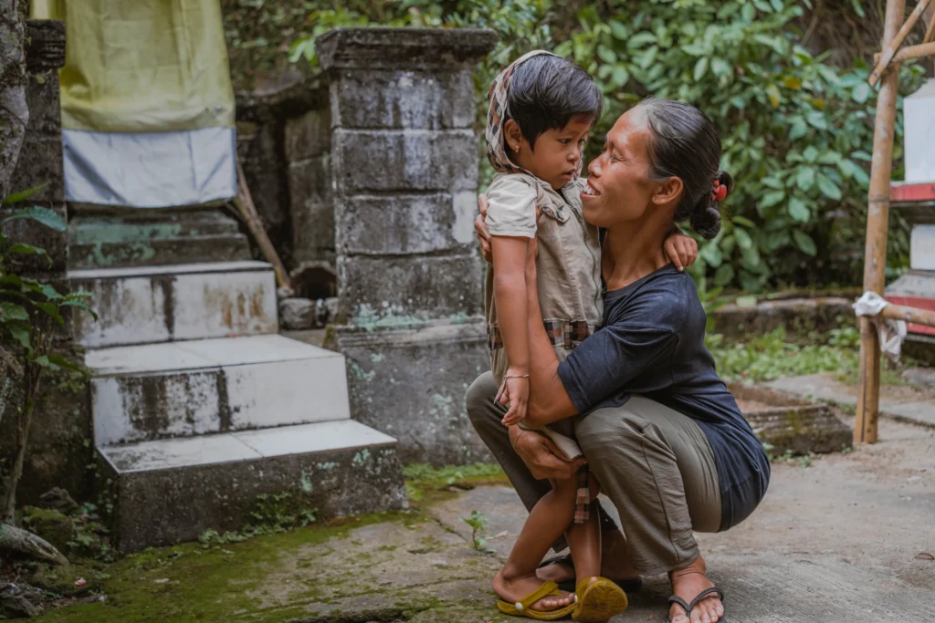 A heartwarming and intimate moment between a mother and her young child, captured in a lush, vibrant garden.