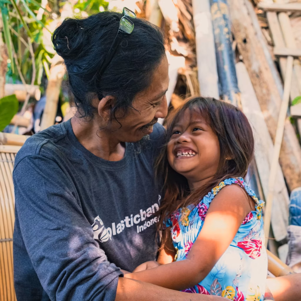 Plastic Bank collection member hugs young family member